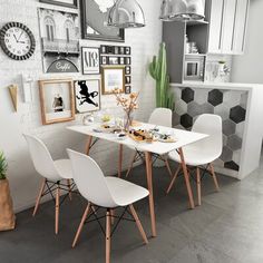 a white table and four chairs in a room with pictures on the wall behind it