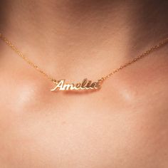 Dainty Gold Necklace With Custom Name, Dainty Gold Charm Necklaces With Name, Dainty Gold Name Charm Necklaces, Gold Nameplate Necklace With Delicate Chain, Dainty Gold Nameplate Charm Necklace, Gold Name Necklace With Delicate Chain For Anniversary, Dainty Gold Nameplate Necklace, Delicate Gold Jewelry With Name Detail, Delicate Gold Jewelry With Name