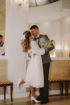 a bride and groom are kissing in front of a mirror at their wedding reception venue