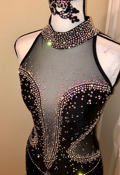 a mannequin wearing a black dress with pink and green beads on it's neck