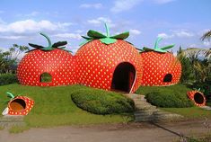 two giant strawberries shaped like houses in the grass