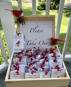 a wooden box filled with lots of cards on top of a porch next to a sign