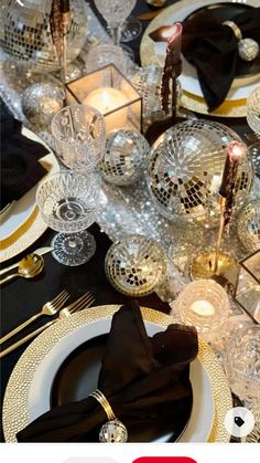 the table is set with black and gold place settings