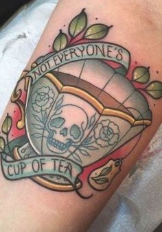 a tattoo with a skull and banner on the arm that says, not everyone's cup of tea