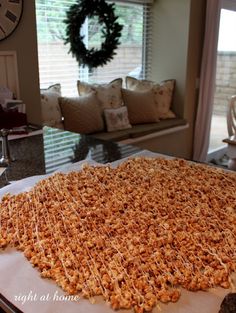 a large cake sitting on top of a table in front of a clock and window