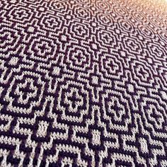 a close up view of a knitted blanket with an intricate design on it's edges