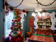 a decorated christmas tree in the corner of a room with presents on the table and other decorations