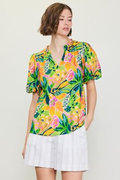 Do the bright thing in this statement-making top. With an artful floral print and bubble sleeves, it's a real mood booster. •Split neckline •Ruffle trim •Puffed short sleeves •Relaxed fit Item Number: 45552 Tropical V-neck Top With Vibrant Print, Spring Printed Puff Sleeve Tops, Spring Printed Puff-sleeve Tops, Printed Puff Sleeve Tops For Spring, Spring Tropical Print Relaxed Fit Blouse, Yellow Vibrant Print Short Sleeve Tops, Spring Blouse With Tropical Print And Relaxed Fit, Spring Tropical Print Relaxed Fit Tops, Spring Tropical Print Tops With Relaxed Fit