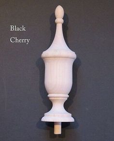 a white candle holder with a black cherry on it