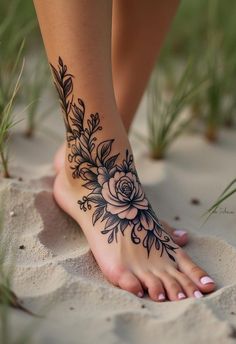 a woman's foot with a flower tattoo on it and grass in the background