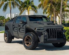 a black hummer truck parked in front of palm trees