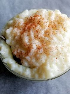 a glass bowl filled with mashed potatoes and cinnamon sprinkled on the top