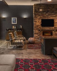 a living room filled with furniture and a flat screen tv mounted on the wall next to a fire place