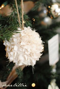 a white ornament hanging from a christmas tree