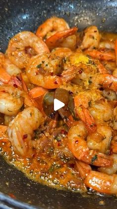 a pan filled with cooked shrimp and olives