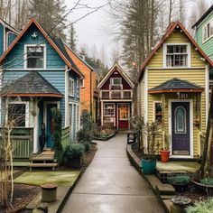 many colorful houses are lined up on the street in front of trees and bushes, along with one another