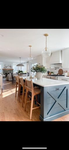 a large kitchen with an island in the middle and chairs at the end, next to a dining room table