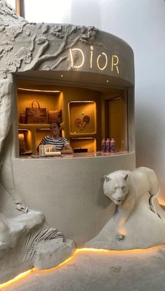 a man sitting in front of a store window with two polar bears and a bear statue