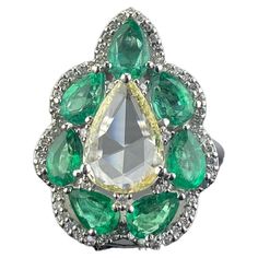 A stunning, art-deco looking, pear shaped 0.86 carat eye clean Rose Cut Diamond centre stone, with 2.66 carat pear shaped Zambian Emerald with great luster and vivid green color. The gemstones are set in solid 18K White Gold. The ring is currently sized at US7, but can be altered. We provide free shipping, and accept returns! Please feel free to message us for more information. Luxury Green Teardrop-shaped Ring, Diamond And Emerald Engagement Ring, Contemporary Engagement Rings, Modern Engagement Rings, Sparkly Jewelry, Zambian Emerald, Diamond Cocktail Rings, Diamond Ring Settings, Yellow Gold Engagement