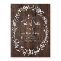 save the date card with an image of a wreath and flowers on wooden planks