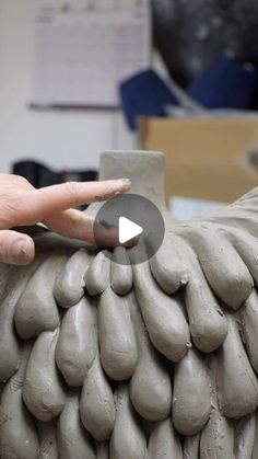 a person is making something out of clay with one hand and the other thumb on it