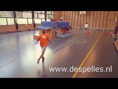 a young boy is running on an indoor basketball court