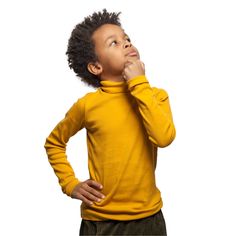 a young boy standing with his hands on his chin and looking up to the sky