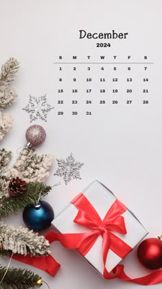 a calendar with christmas decorations and presents on it, next to a small fir tree