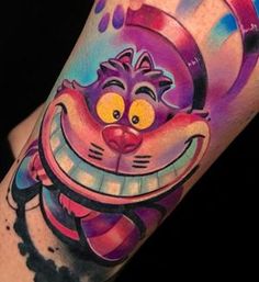 a colorful tattoo on the arm of a person with an evil clown face painted on it