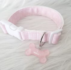 a pink dog collar with a bone charm