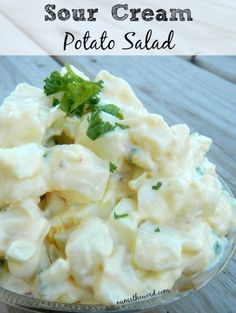 a bowl full of potato salad with parsley on top and the words sour cream potato salad