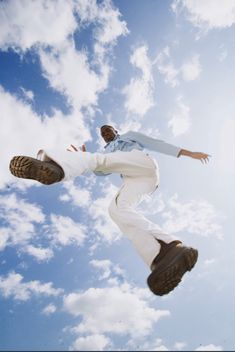 a man flying through the air while riding a skateboard on top of his feet