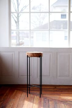 a wooden table sitting in front of a window on top of a hard wood floor