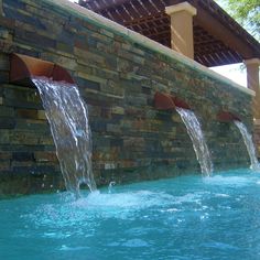 the water is running down the side of the building and into the swimming pool area