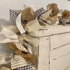 an old dresser is adorned with burlocks and ribbons