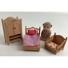 a teddy bear sitting next to a doll bed