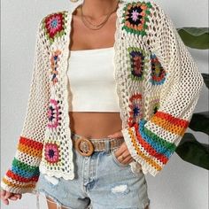 a woman wearing shorts and a crochet jacket