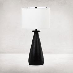 a black table lamp with a white shade on it