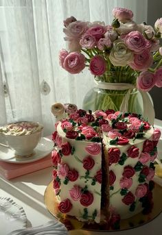 the cake is decorated with pink flowers and has two slices cut out to show it's side