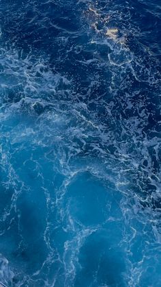 the water is blue and foamy as it floats through the ocean on a boat