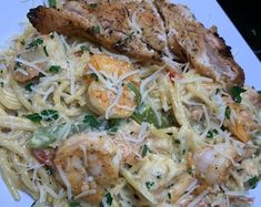 a white plate topped with pasta and shrimp