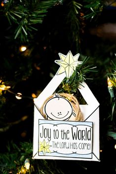 a christmas ornament hanging on a tree with the words joy to the world