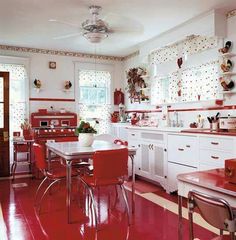 a red and white kitchen with polka dot wallpaper on the walls, flooring and cabinets