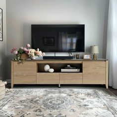 a living room scene with focus on the entertainment center and large screen tv in the background