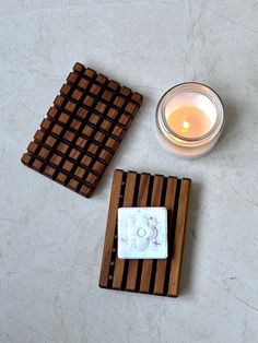 two wooden coasters and a candle on a table