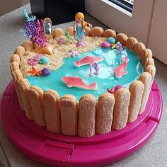 a birthday cake decorated with toys and sand