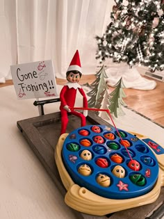 an elf is sitting on top of a game board with a sign that says gone fishing