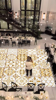 an overhead view of a dining room with tables and chairs in the center, lit up by candles