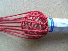 a red and white whisk sitting on top of a table