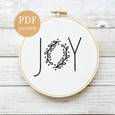 a cross stitch pattern with the word joy on it and a wreath in the middle